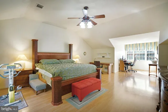 a bedroom with a large bed and a chandelier