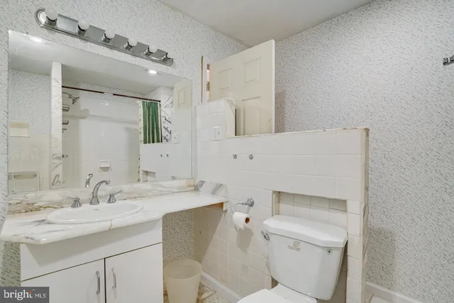 a bathroom with a sink toilet vanity and tub