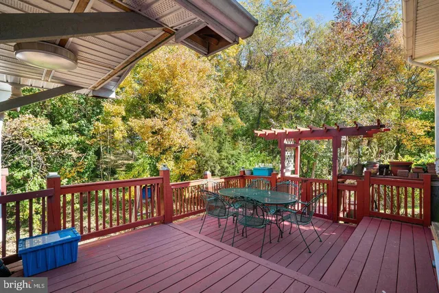 a view of deck with table and chairs under wooden floor and fence