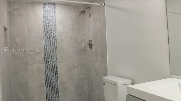 a bathroom with a shower a toilet and a sink