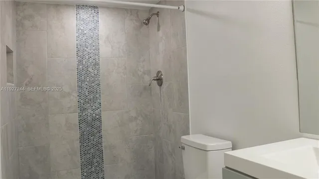 a bathroom with a shower a toilet and a sink