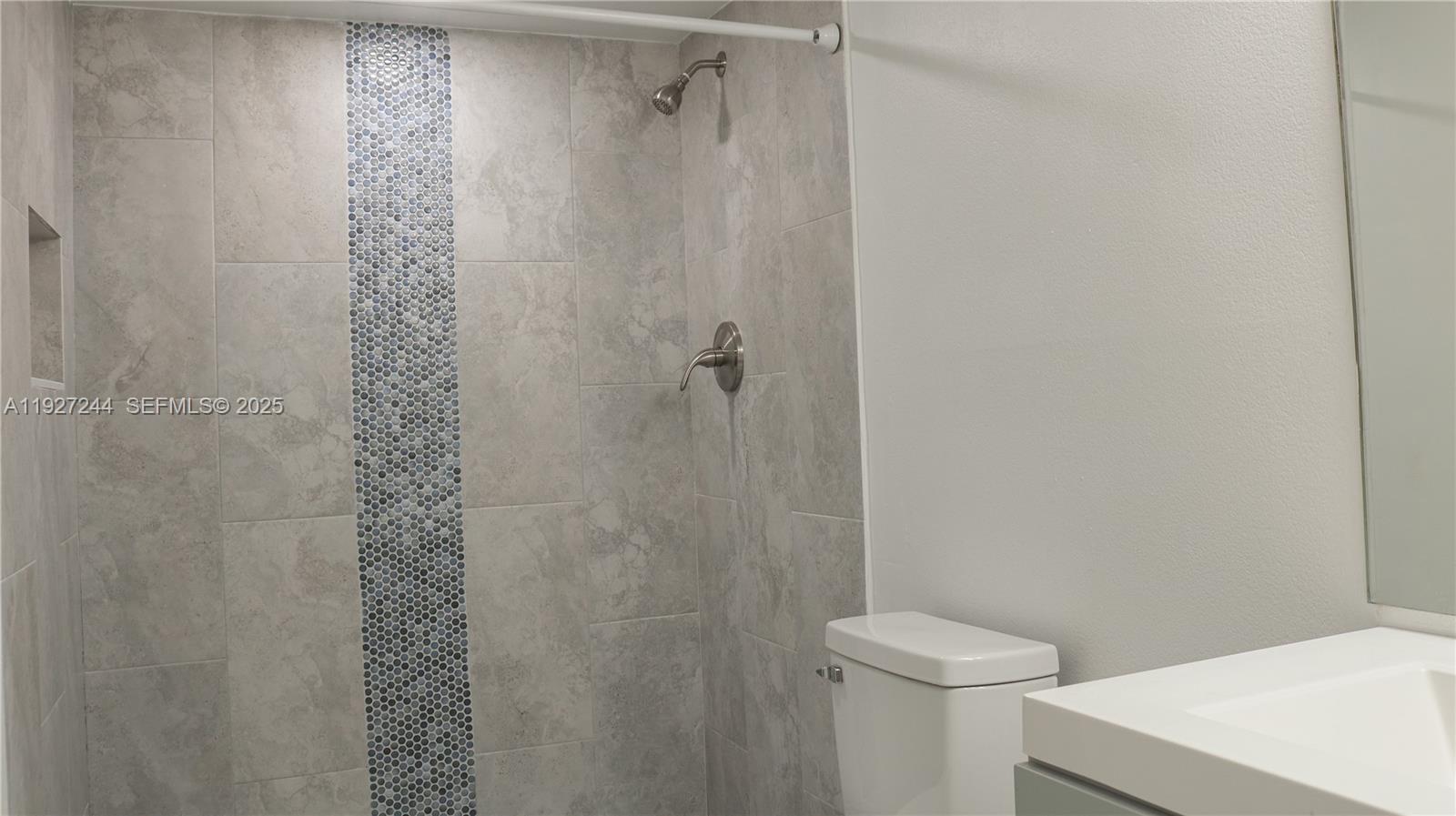 9421 Evergreen Place, Unit 103 Davie, FL 33324 - Photo 12 of 32 a bathroom with a shower a toilet and a sink