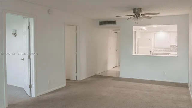 an empty room with a window and a ceiling fan