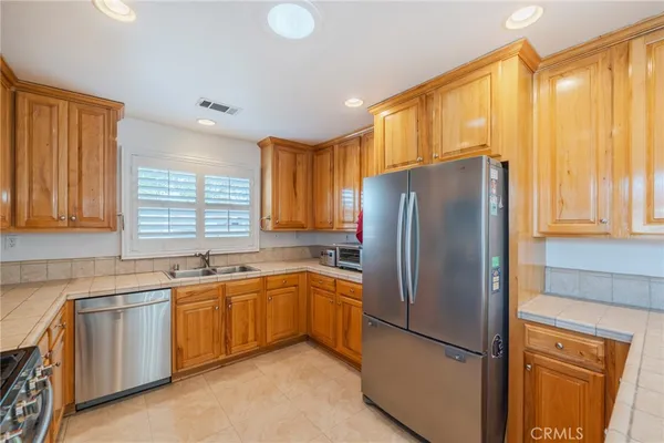 a kitchen with stainless steel appliances granite countertop a refrigerator and a sink