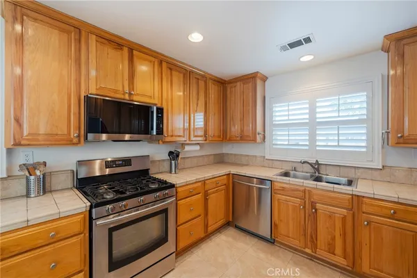 a kitchen with stainless steel appliances granite countertop white cabinets a sink and a stove