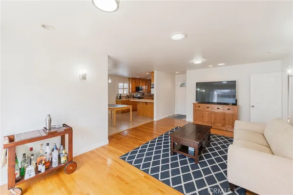 a living room with furniture a flat screen tv and kitchen view