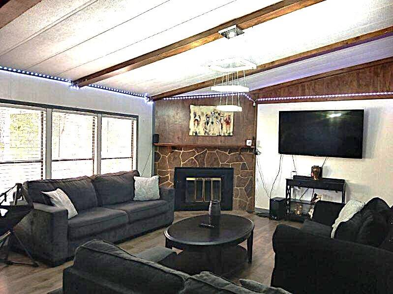 9153 Bouncer Road Quinlan, TX 75474 - Photo 5 of 27 a living room with furniture a fireplace and a flat screen tv