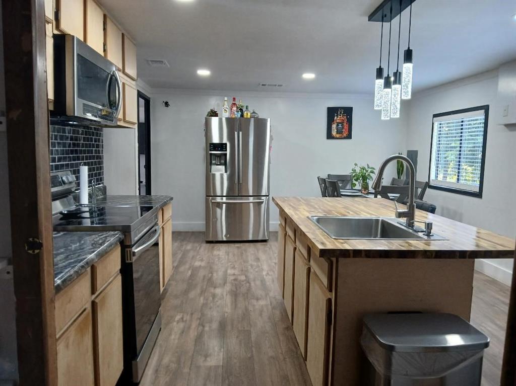 9153 Bouncer Road Quinlan, TX 75474 - Photo 8 of 27 a kitchen with stainless steel appliances granite countertop a sink a stove and refrigerator