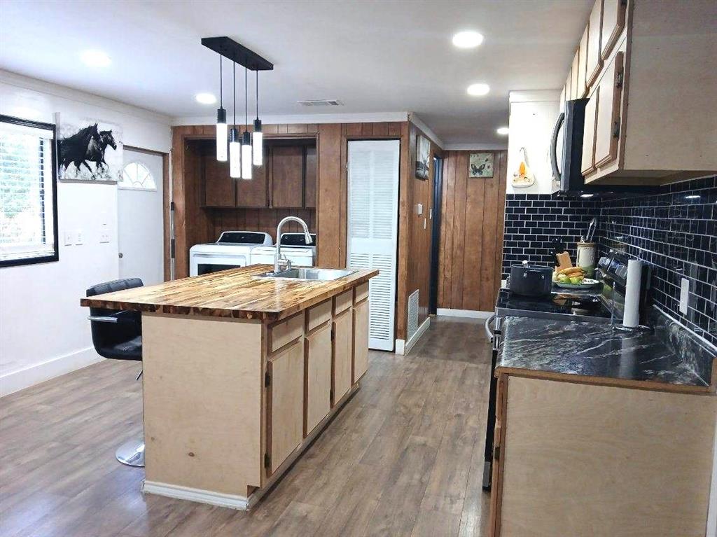9153 Bouncer Road Quinlan, TX 75474 - Photo 9 of 27 a kitchen with stainless steel appliances granite countertop a sink stove and refrigerator