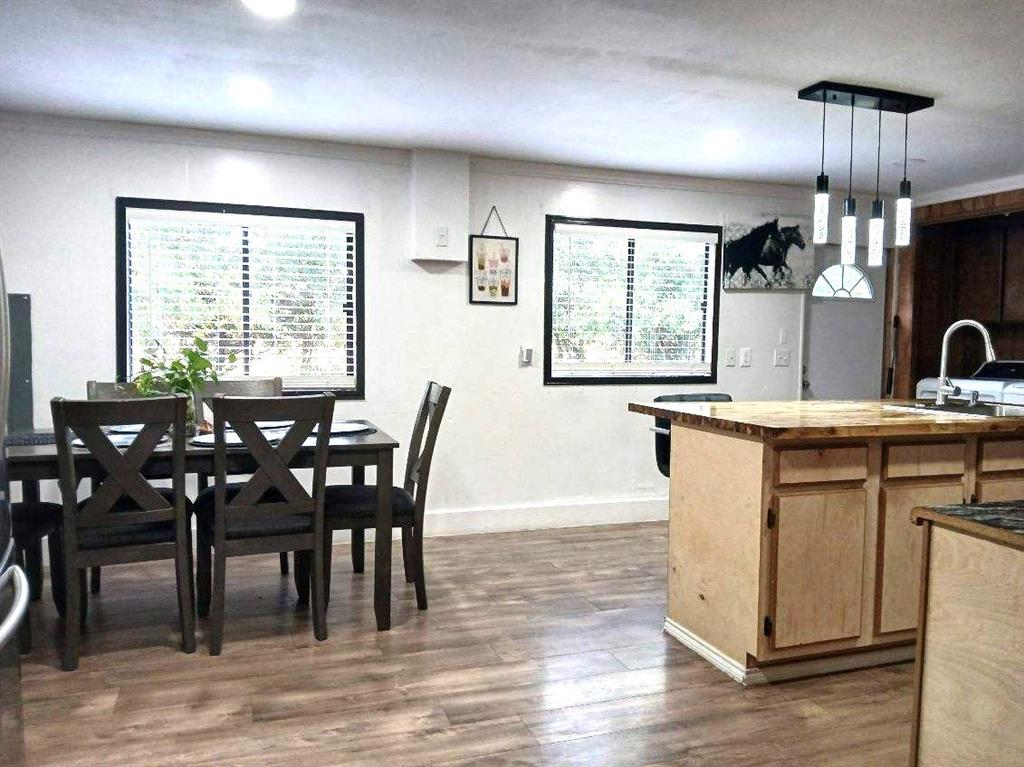 9153 Bouncer Road Quinlan, TX 75474 - Photo 10 of 27 a view of a dining room with furniture window and wooden floor