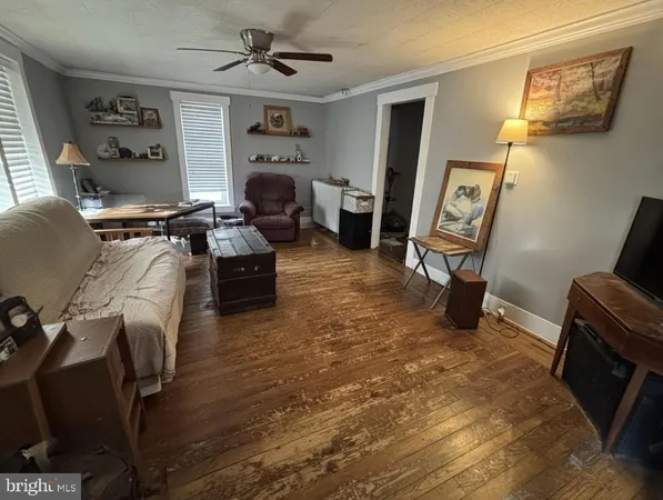 a living room with furniture a flat screen tv and a window