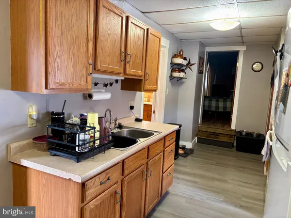 a kitchen with stainless steel appliances granite countertop a stove a refrigerator and a sink with wooden floor