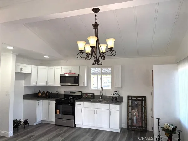 a kitchen with stainless steel appliances granite countertop wooden cabinets a stove a sink and dishwasher