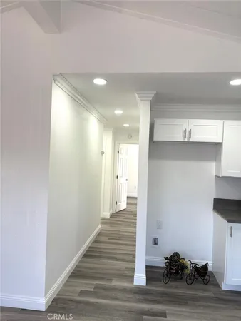 a view of a hallway with wooden floor and cabinet