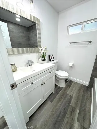 a bathroom with a double vanity sink mirror and toilet