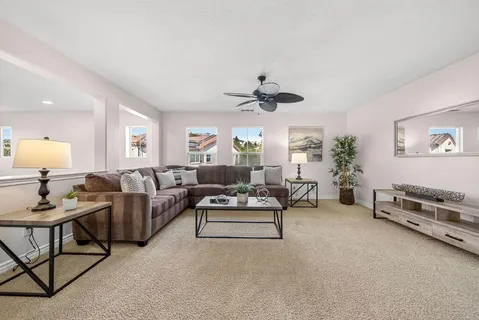 a spacious bedroom with a bed a couch and potted plant on the dresser
