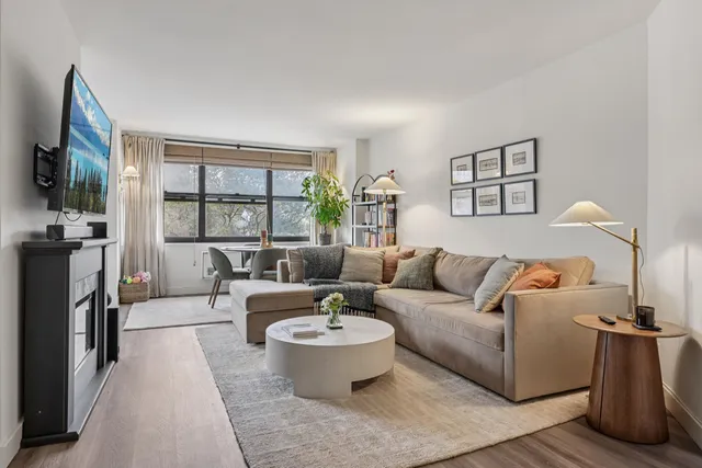 a living room with furniture a flat screen tv and a fireplace