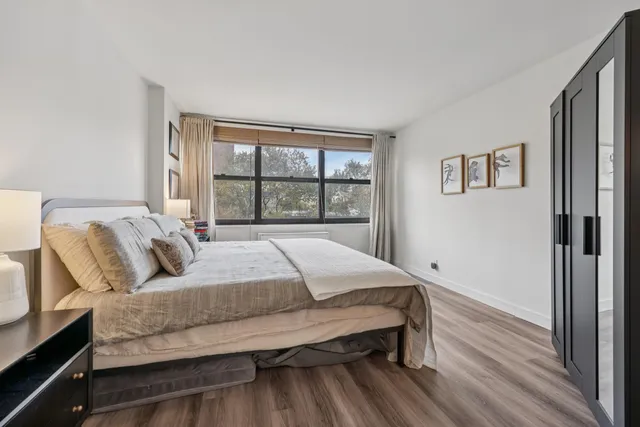 a bedroom with a bed and wooden floor