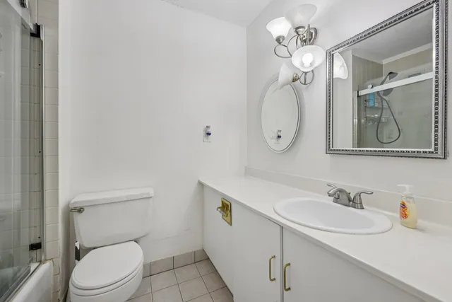 a bathroom with a granite countertop toilet sink and mirror