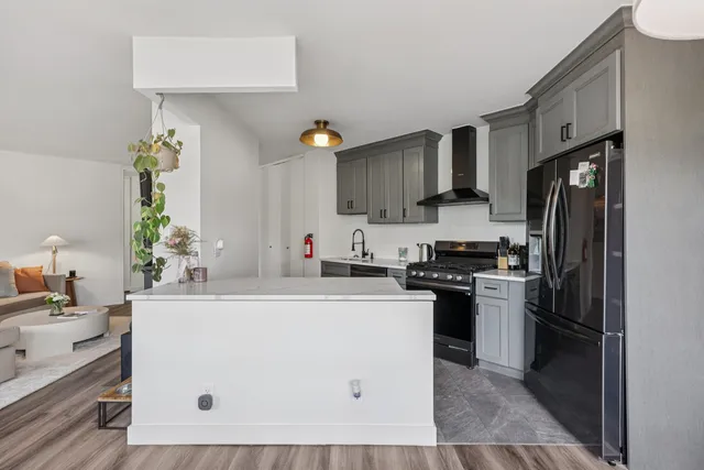 a kitchen with stainless steel appliances a sink a stove a refrigerator cabinets and a counter top space