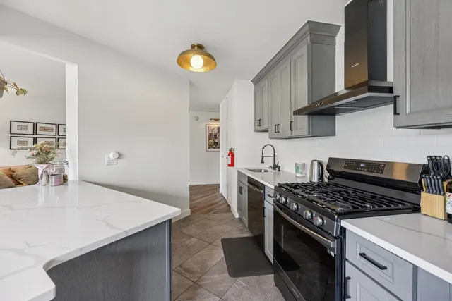 a kitchen with stainless steel appliances granite countertop a sink stove and cabinets