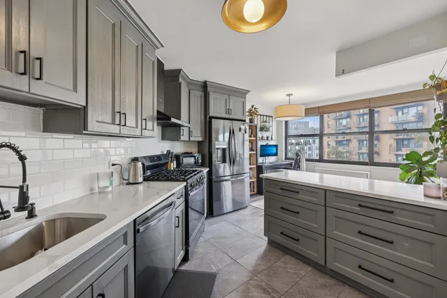 a kitchen with granite countertop a sink stainless steel appliances and cabinets