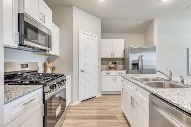 a kitchen with granite countertop a sink stove and refrigerator