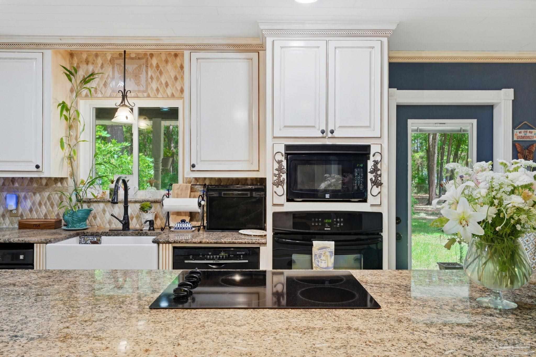6930 Summit Way Milton, FL 32570 - Photo 20 of 71 a kitchen with granite countertop a stove a sink and a counter space