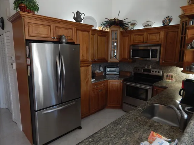 a kitchen with stainless steel appliances granite countertop a refrigerator stove and microwave
