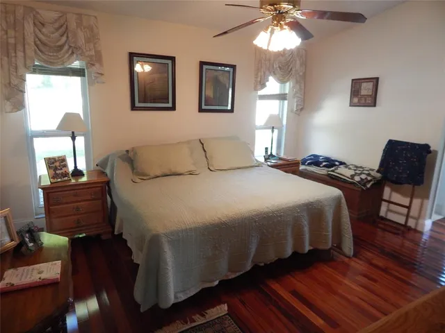 a bedroom with a bed and wooden floor
