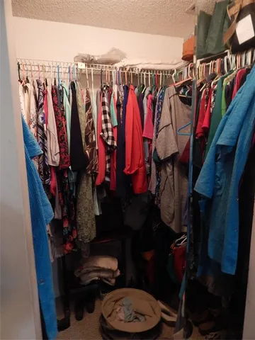 a view of walk in closet with clothes and shoes