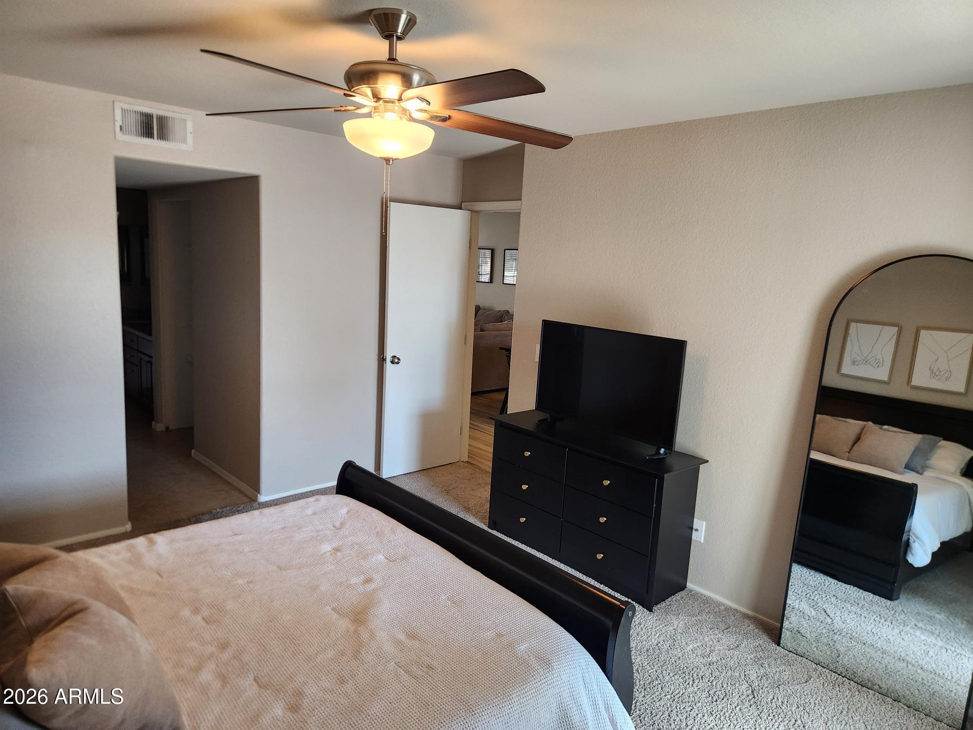 860 North McQueen Road, Unit 1145 Chandler, AZ 85225 - Photo 21 of 63 a bedroom with a bed and a flat tv screen on the dresser