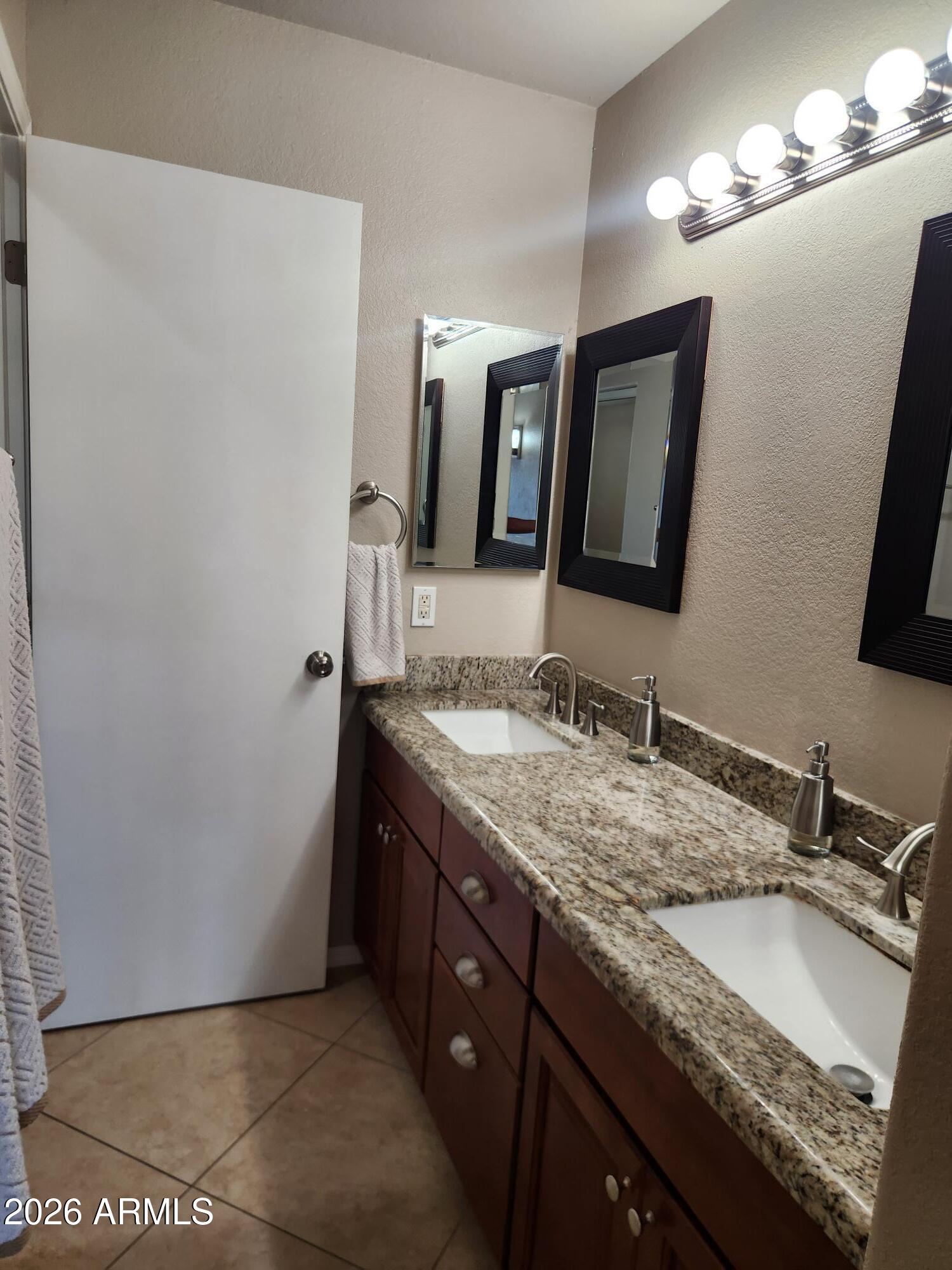 860 North McQueen Road, Unit 1145 Chandler, AZ 85225 - Photo 29 of 63 a bathroom with a granite countertop sink and a mirror