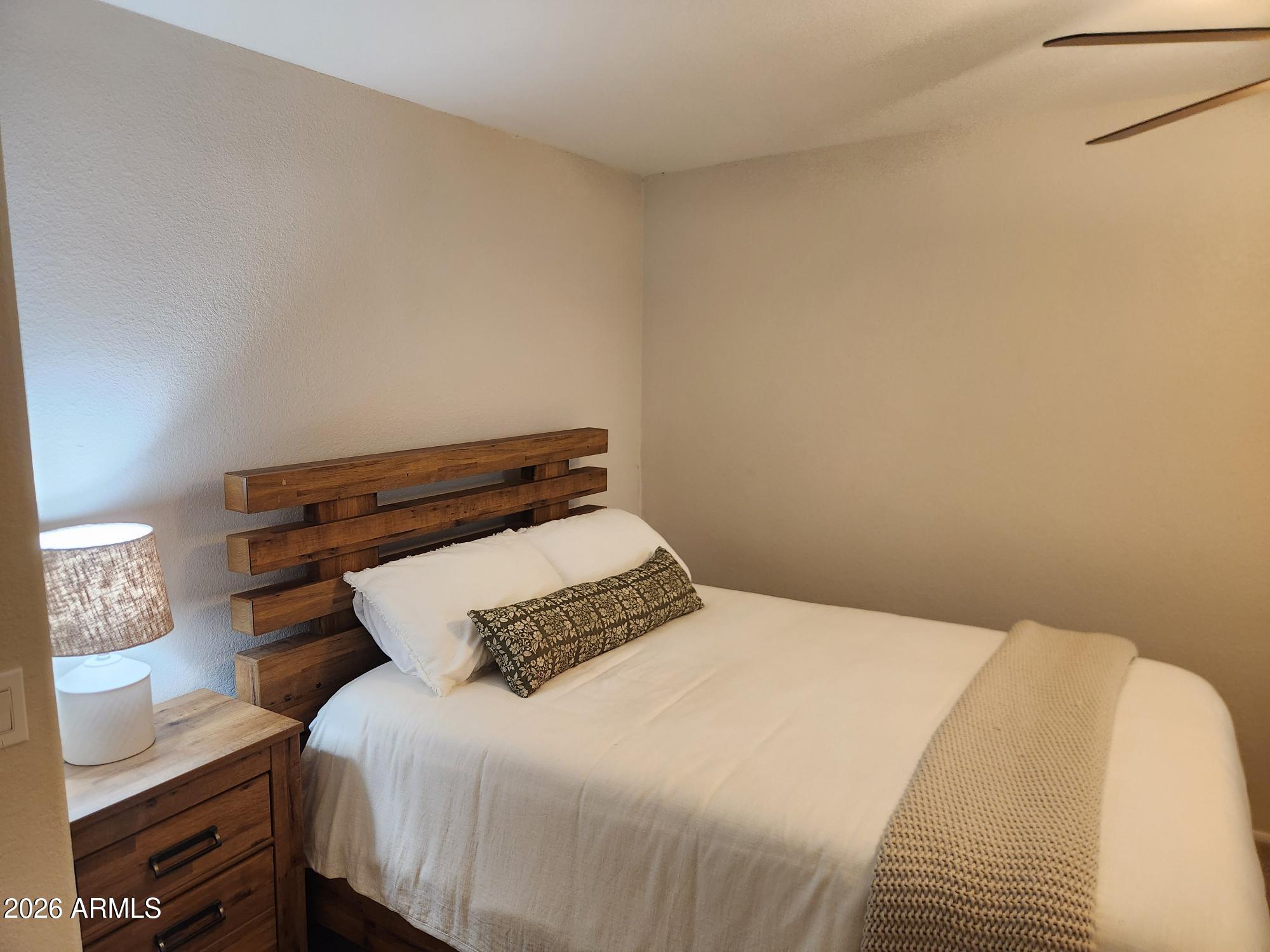 860 North McQueen Road, Unit 1145 Chandler, AZ 85225 - Photo 39 of 63 a bedroom with a bed and wooden floor