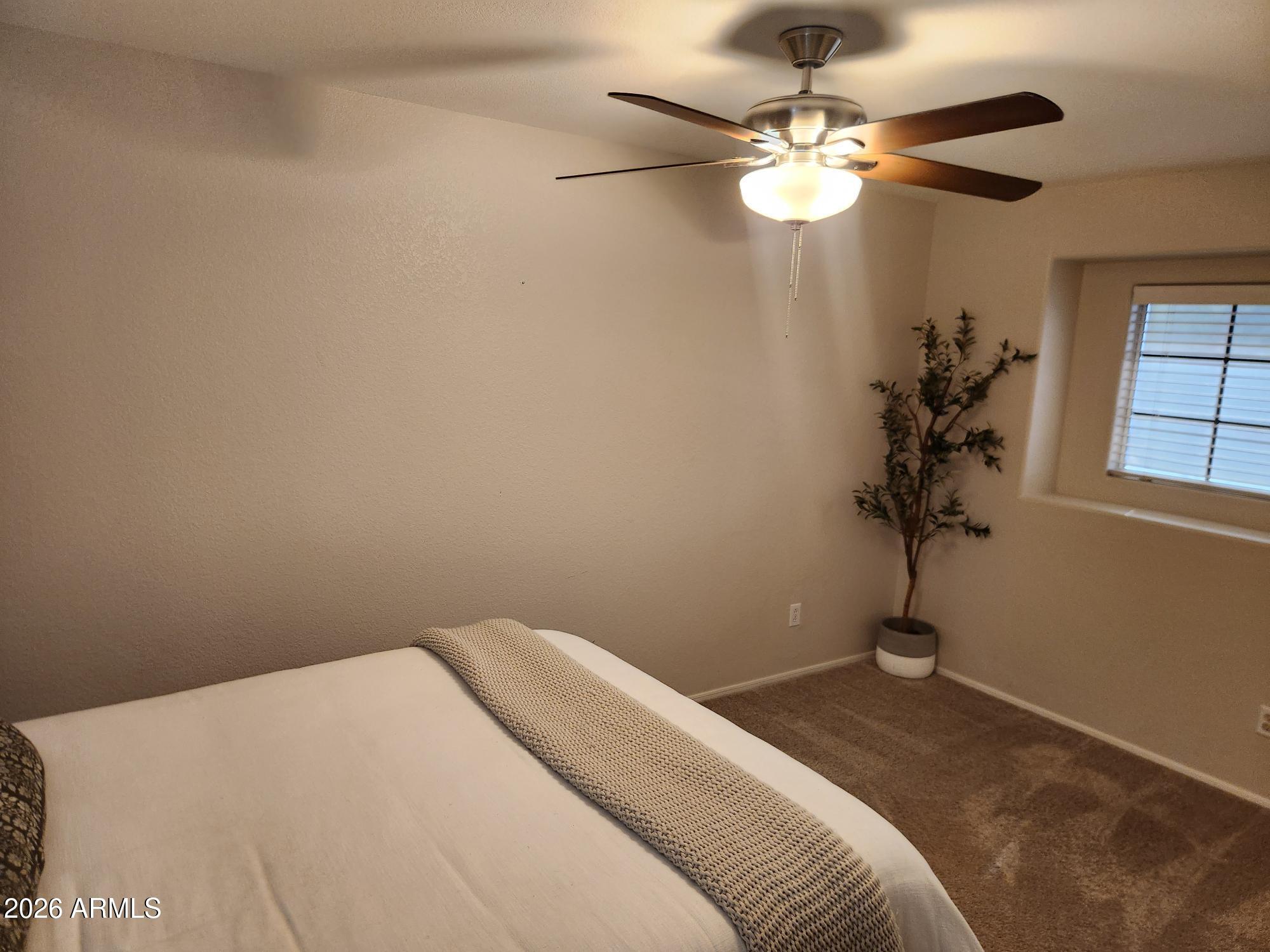 860 North McQueen Road, Unit 1145 Chandler, AZ 85225 - Photo 41 of 63 a bedroom with a bed and a chandelier