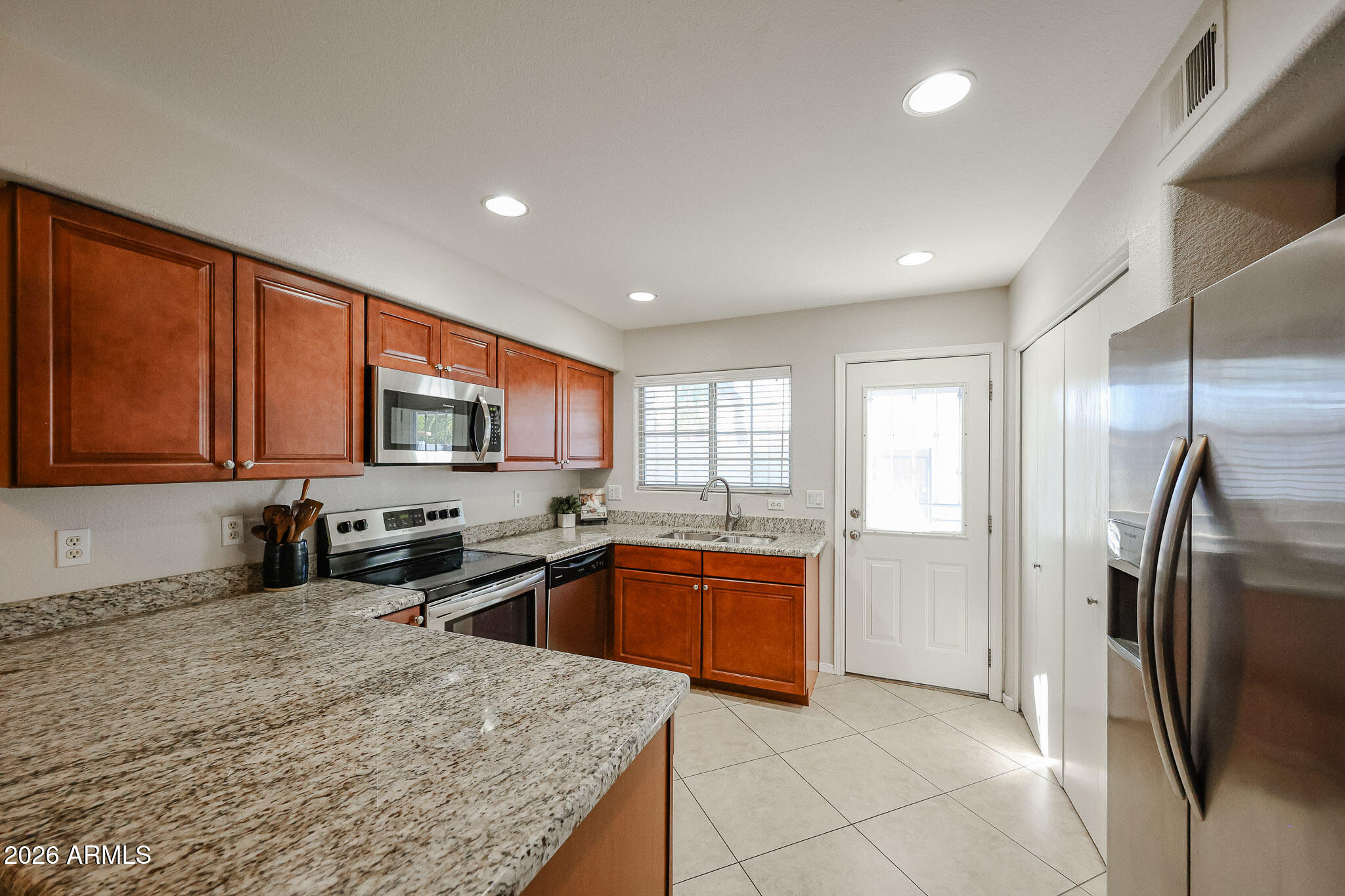 860 North McQueen Road, Unit 1145 Chandler, AZ 85225 - Photo 7 of 63 a kitchen with stainless steel appliances granite countertop a refrigerator a sink a stove top oven and a refrigerator