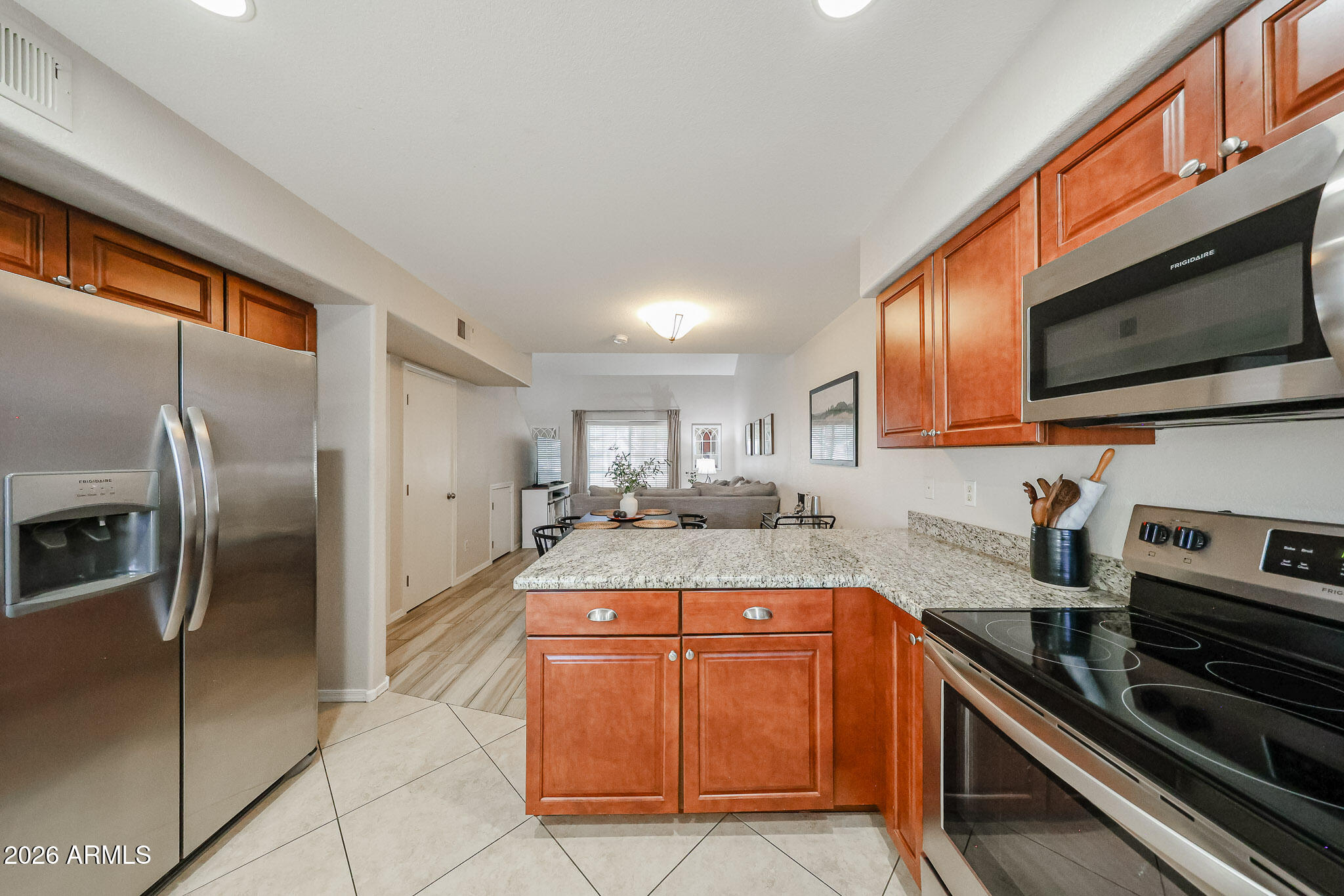 860 North McQueen Road, Unit 1145 Chandler, AZ 85225 - Photo 9 of 63 a kitchen with stainless steel appliances granite countertop a stove a sink and a microwave