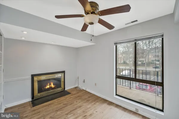 a view of an empty room with a fireplace and a window