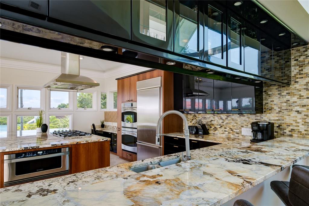 624 South Casey Key Road Nokomis, FL 34275 - Photo 24 of 75 a kitchen with stainless steel appliances kitchen island granite countertop a stove a sink and a microwave