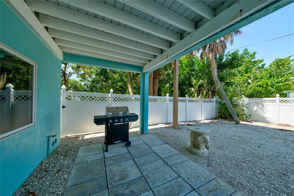 624 South Casey Key Road Nokomis, FL 34275 - Photo 54 of 75 a view of a patio with table and chairs and potted plants with wooden floor