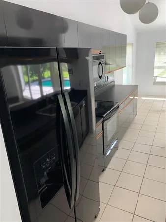 a kitchen with granite countertop a stove a microwave and a shower