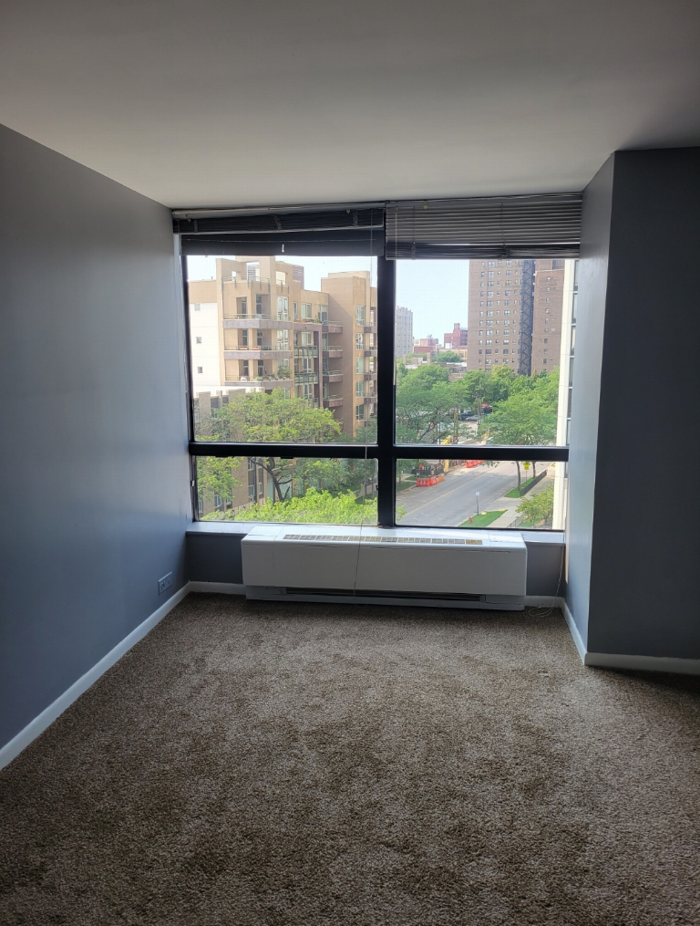 5415 North Sheridan Road, Unit 609 Chicago, IL 60640 - Photo 13 of 25 an empty room with large windows and city view