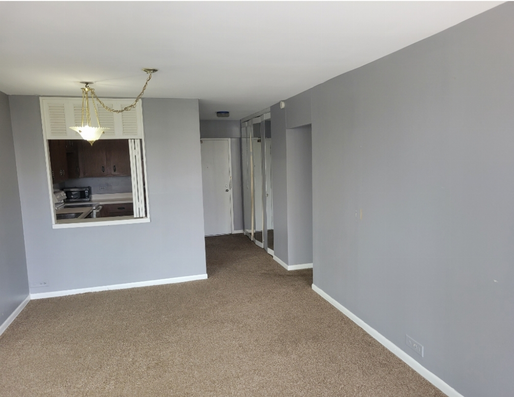 5415 North Sheridan Road, Unit 609 Chicago, IL 60640 - Photo 6 of 25 a view of an empty room with a fireplace and a window