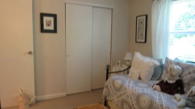 a bed sitting in a bedroom next to a window