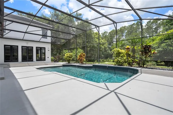 a view of a patio with chairs and floor to ceiling window