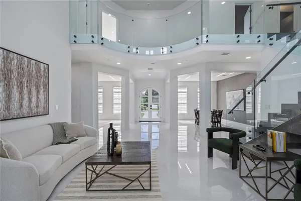 a living room with furniture kitchen view and a chandelier