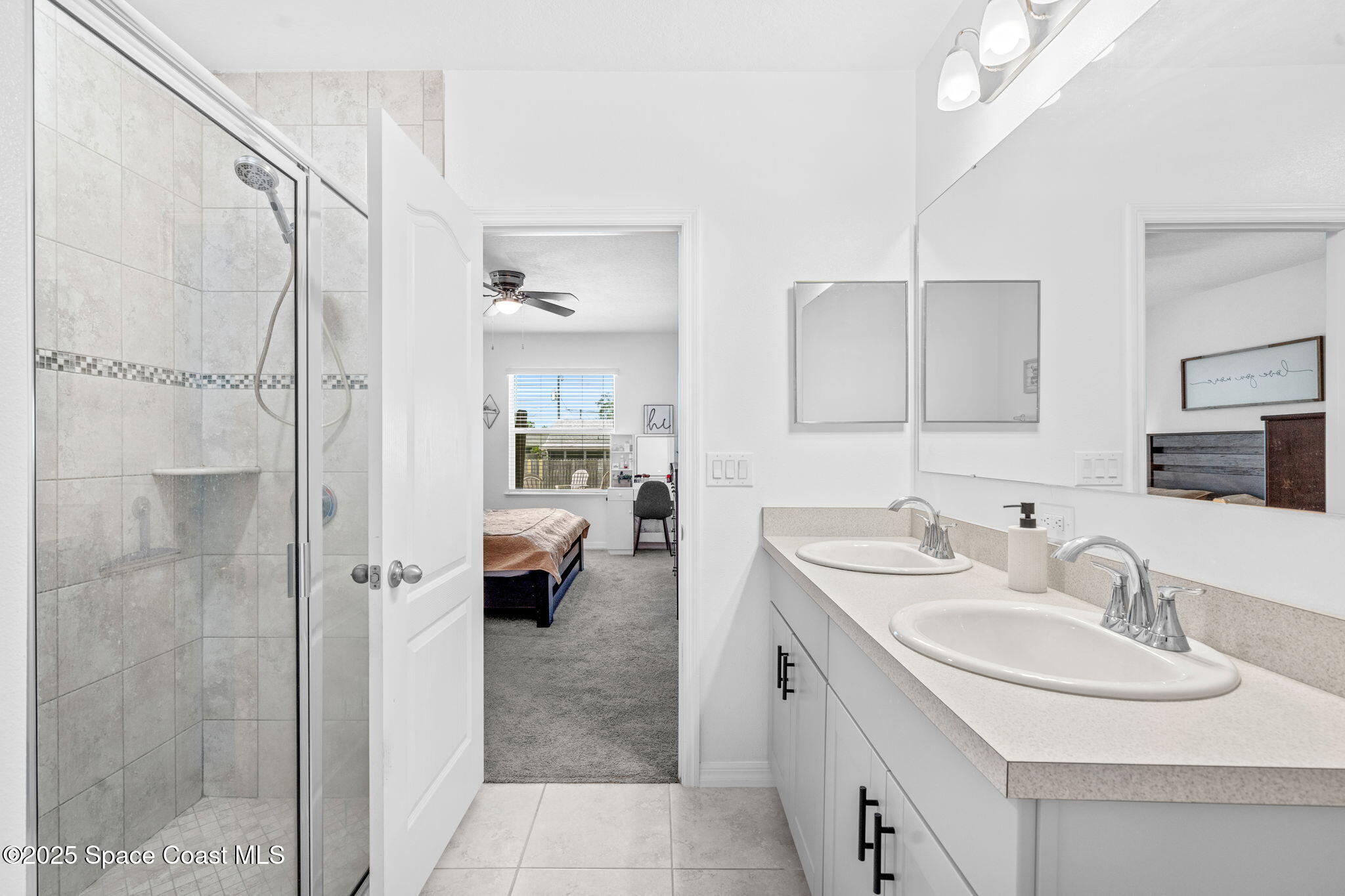 6162 Rena Avenue Cocoa, FL 32927 - Photo 17 of 42 a en suite bathroom with a sink a mirror a shower and a mirror