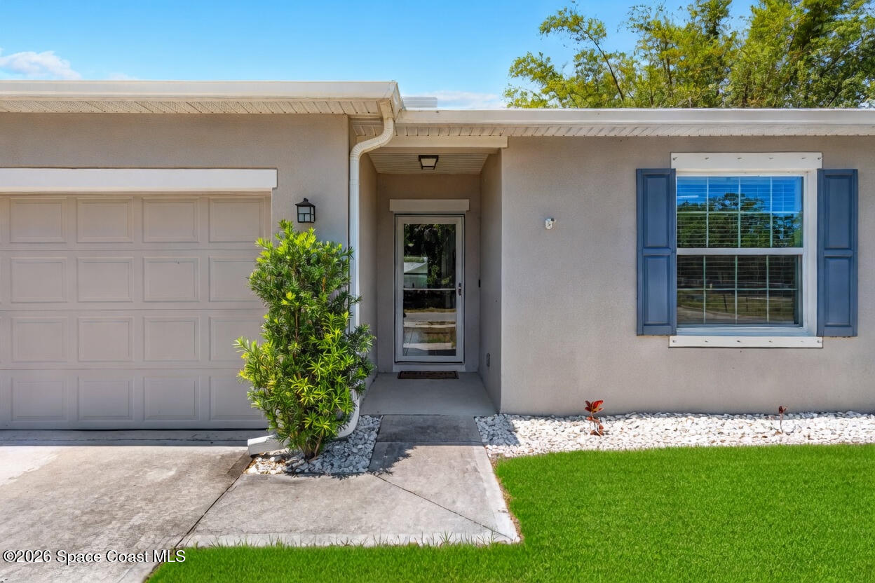 6162 Rena Avenue Cocoa, FL 32927 - Photo 2 of 42 a front view of a house with a yard and garage