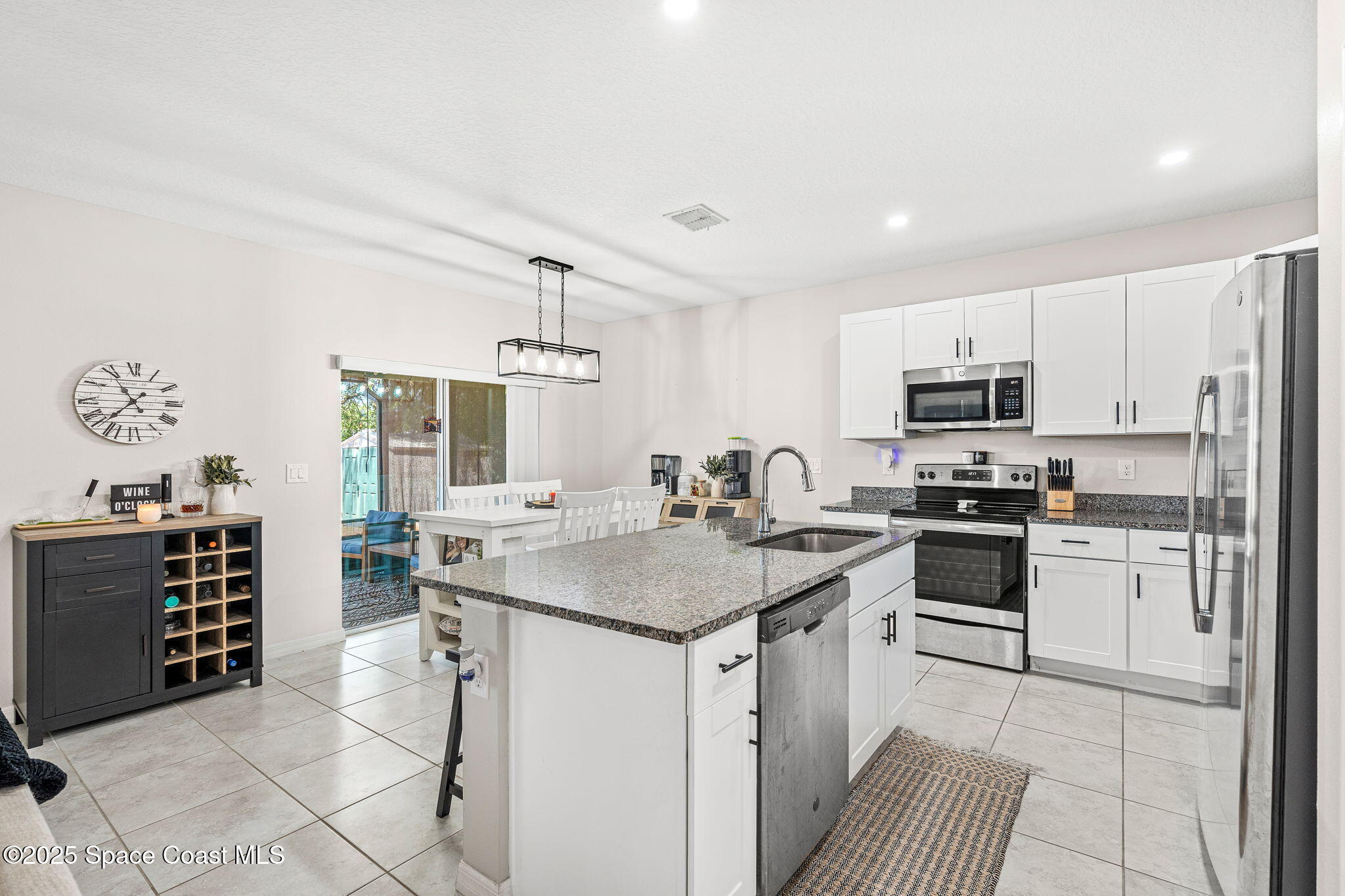 6162 Rena Avenue Cocoa, FL 32927 - Photo 10 of 42 a kitchen with stainless steel appliances kitchen island granite countertop a sink stove and refrigerator