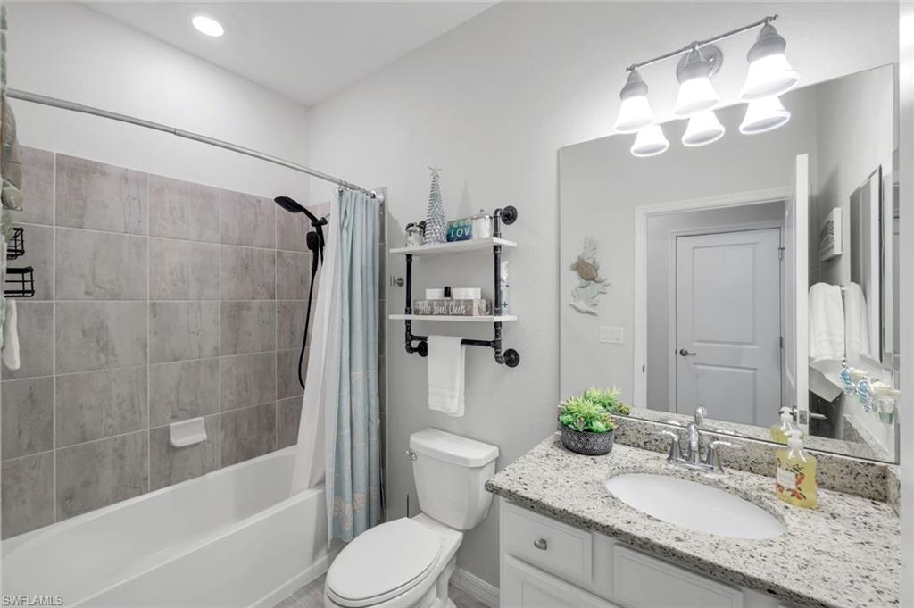 2193 Clementine Street Naples, FL 34120 - Photo 23 of 36 a bathroom with a granite countertop sink toilet and shower
